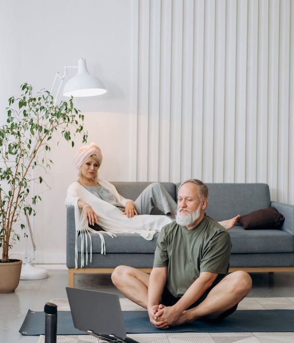 Woman in a calm yoga pose in a bright, minimalist room.